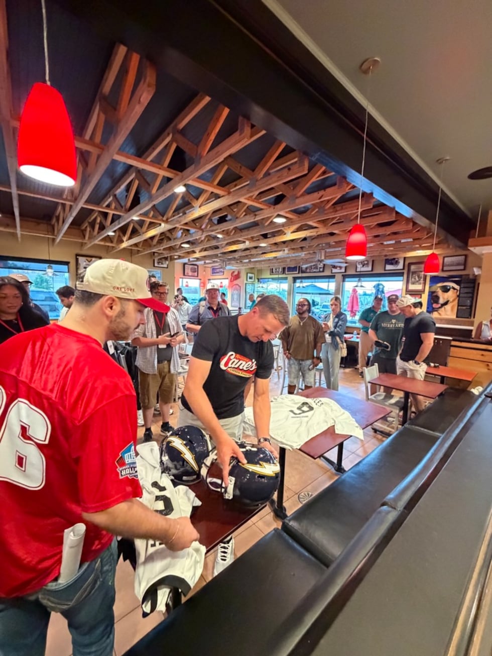 Drew Brees serves customers behind the counter at Raising Cane’s ahead of his Pro Football...