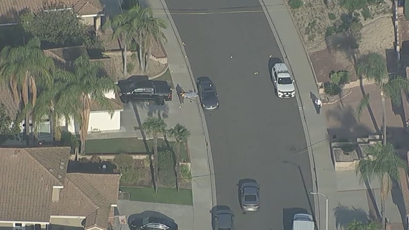 Video shows the scene with one body on the ground covered in a sheet and the other still in...